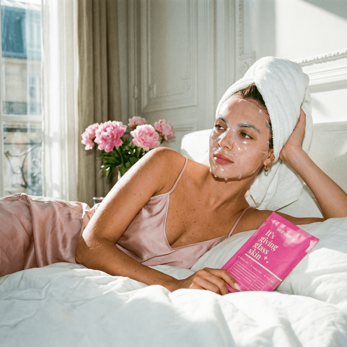 Woman relaxing in bed with WellNature collagen mask